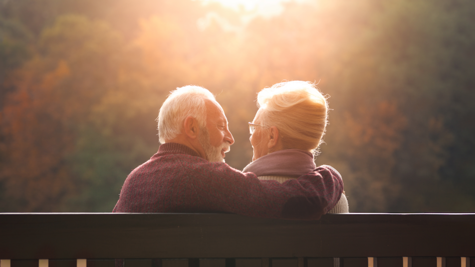 Ein älteres Paar sitzt auf der Bank und schaut sich an